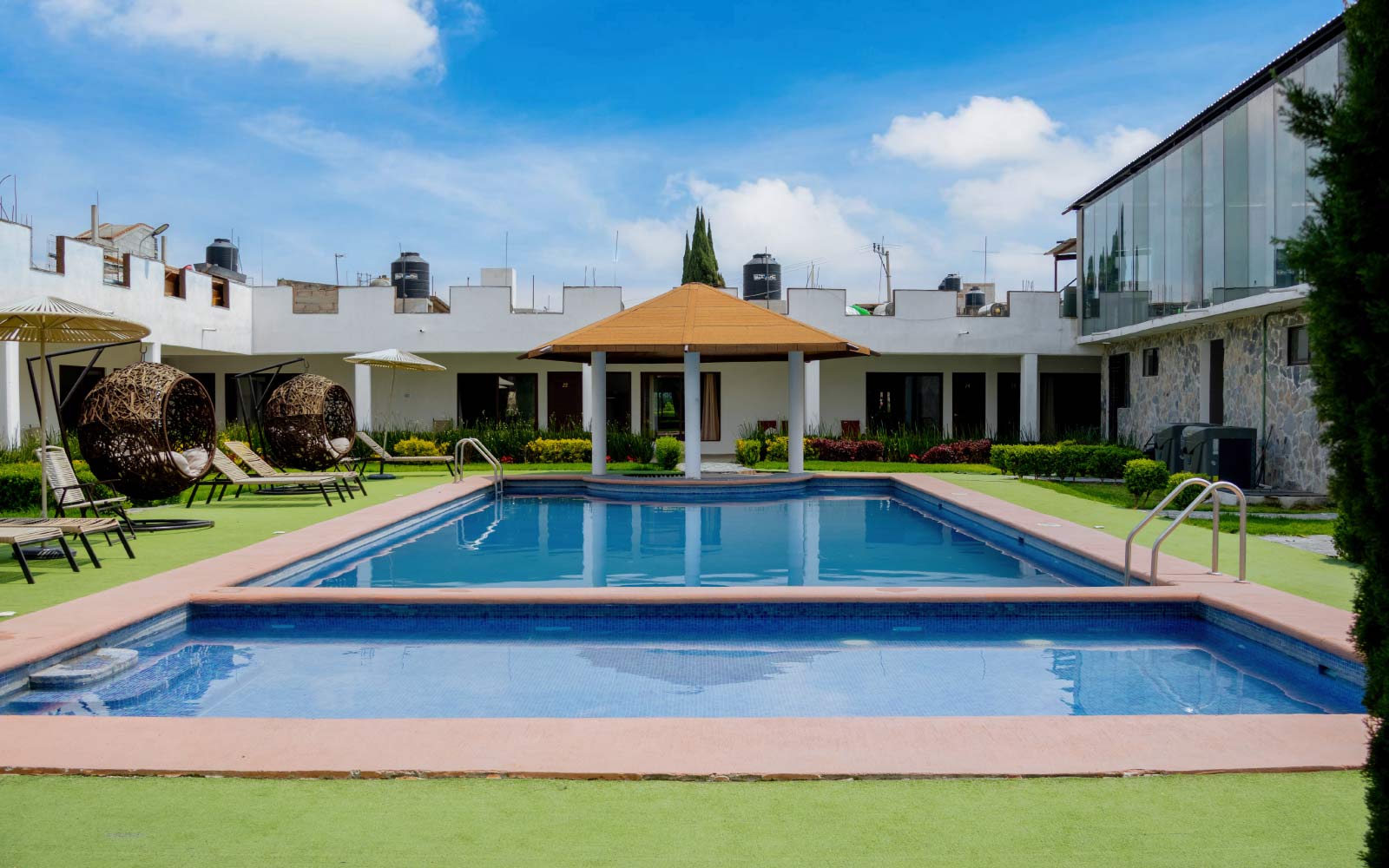 Camastros y sombrillas junto a la piscina climatizada